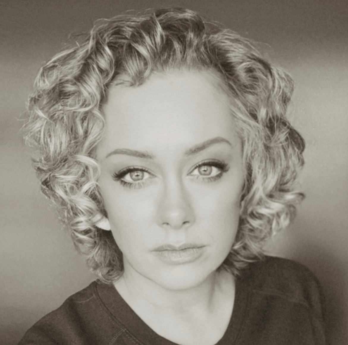 Professional black-and-white portrait of a female chaplain training leader with short curly blonde hair