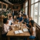Christian friends gathered around a coffee shop table sharing conversation and Bible study.